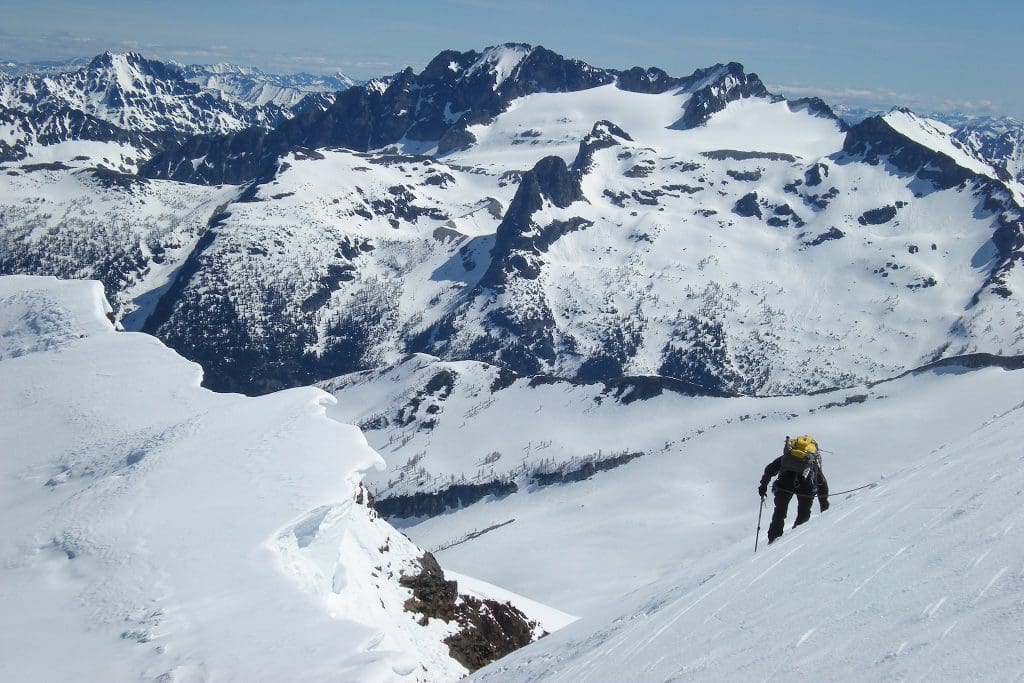 April 2022 - Park of the Month 24 Climber on slope with mountain peaks in a background.